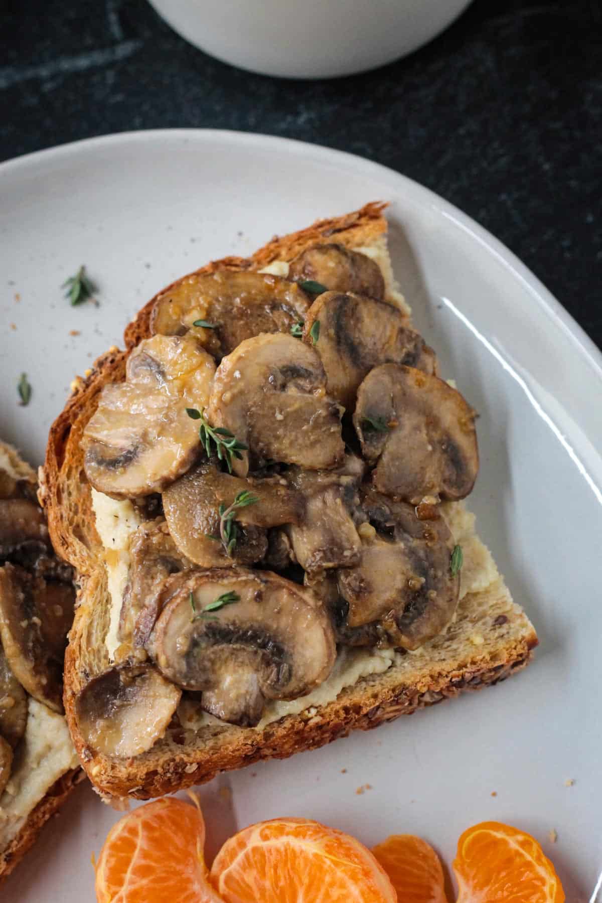 Close up of sautéed mushrooms over vegan ricotta on toast.