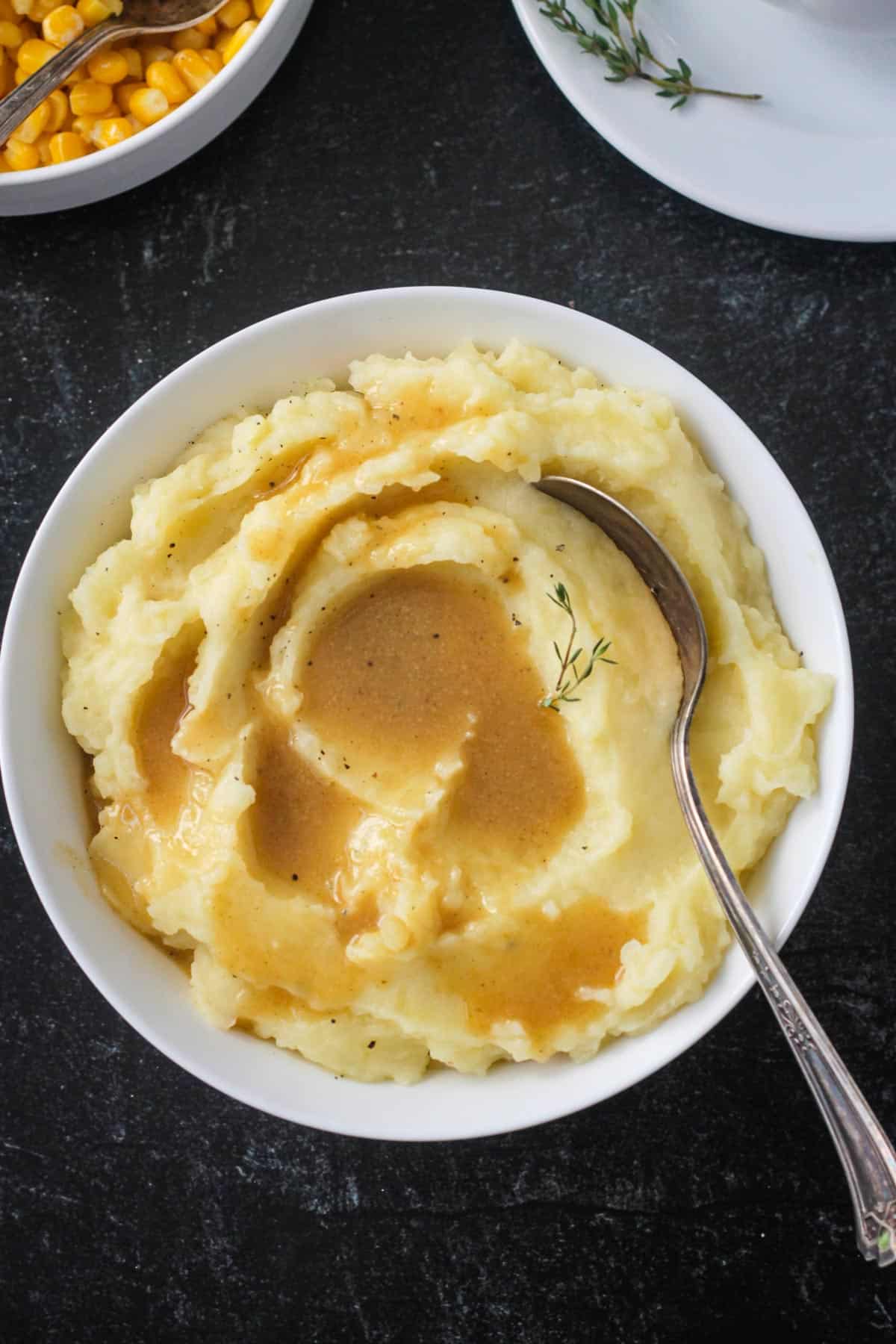 Bowl of mashed potatoes topped with vegan gravy.