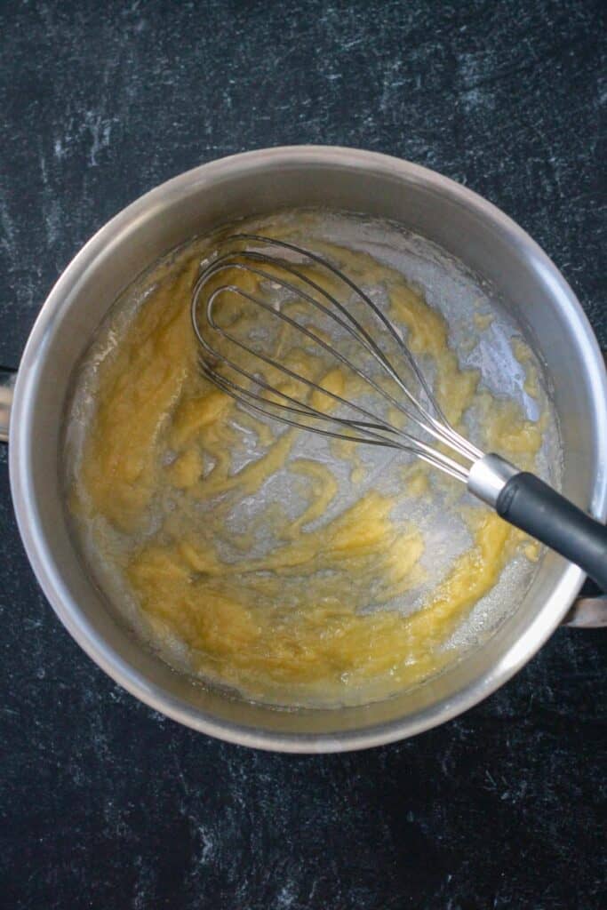 Roux in a pot with a whisk.