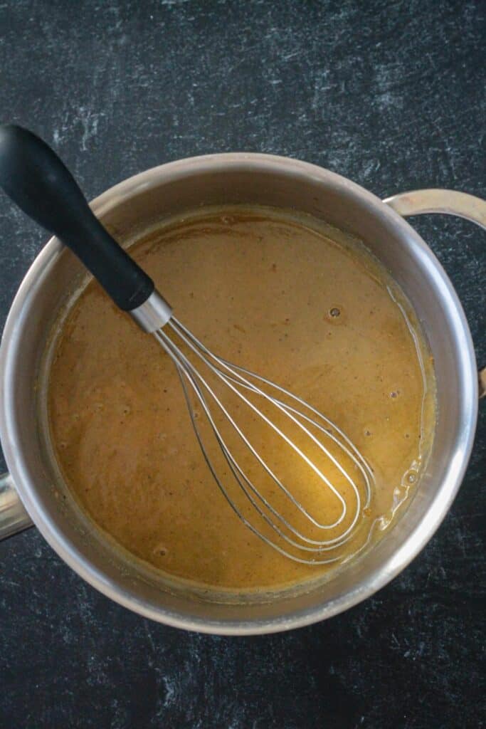 A small amount of broth mixed with the roux to create a smooth texture.