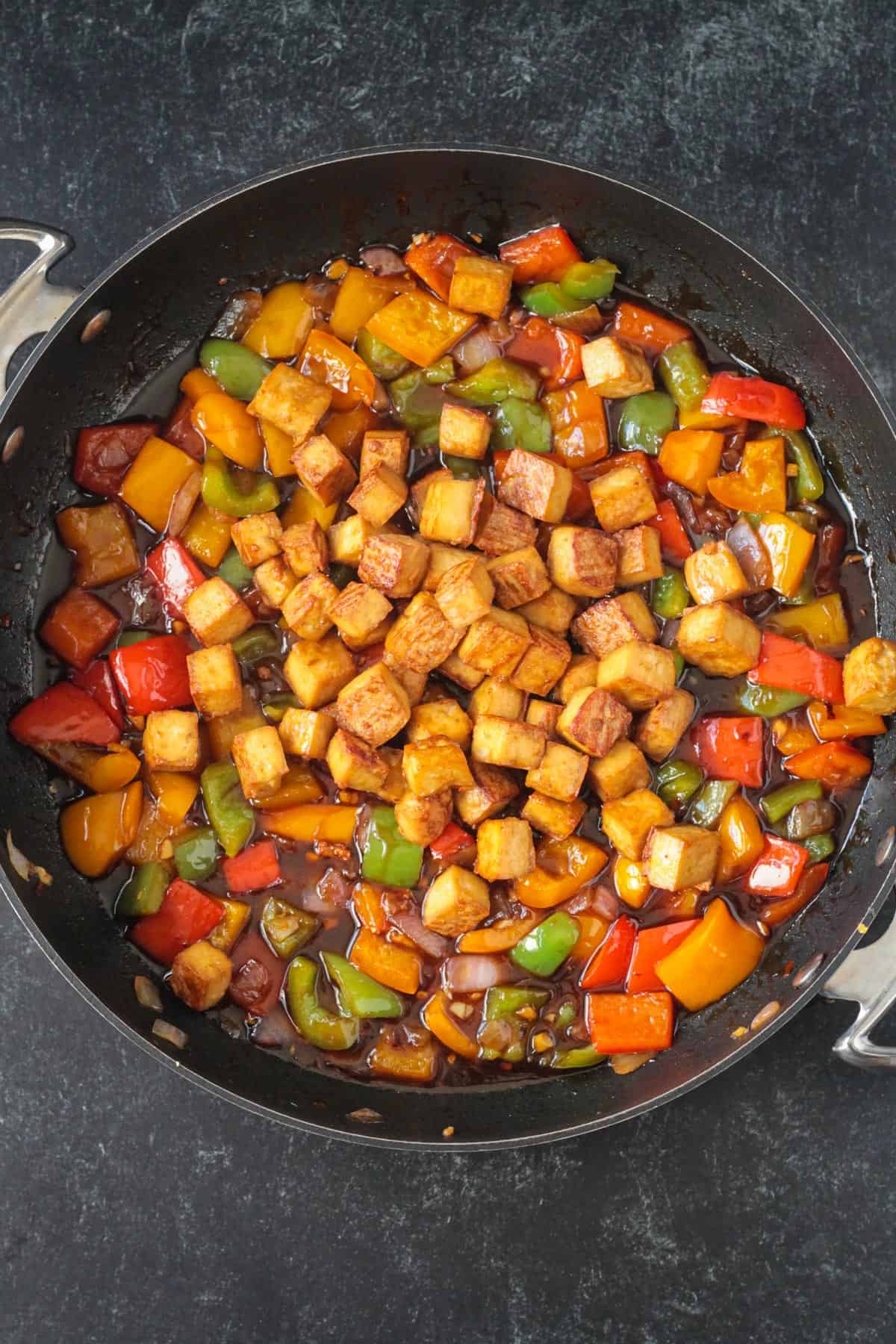 Baked tofu added to the veggies in the skillet.