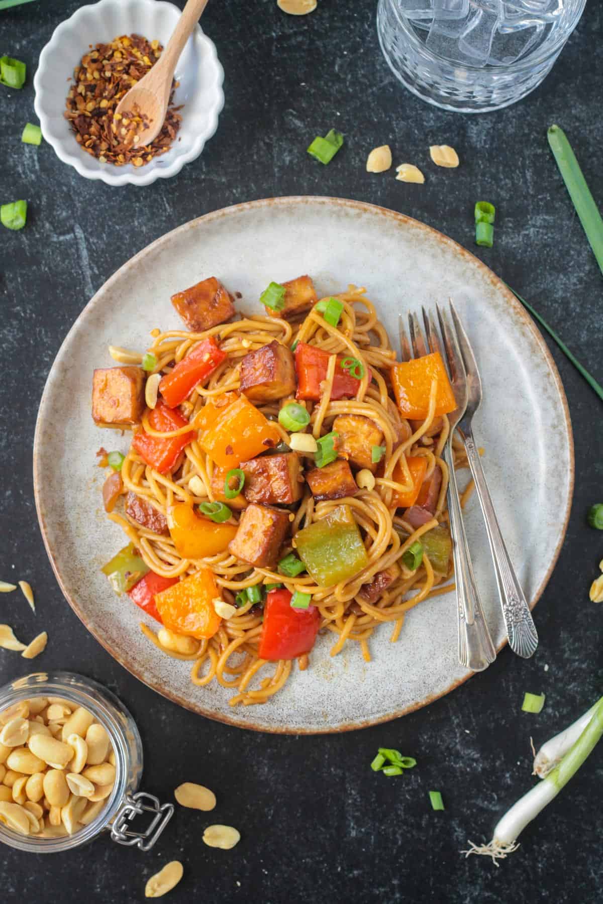 Kung Pao Tofu with noodles on a plate with two forks.