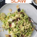 Shaved brussels sprouts salad on a plate with two forks.
