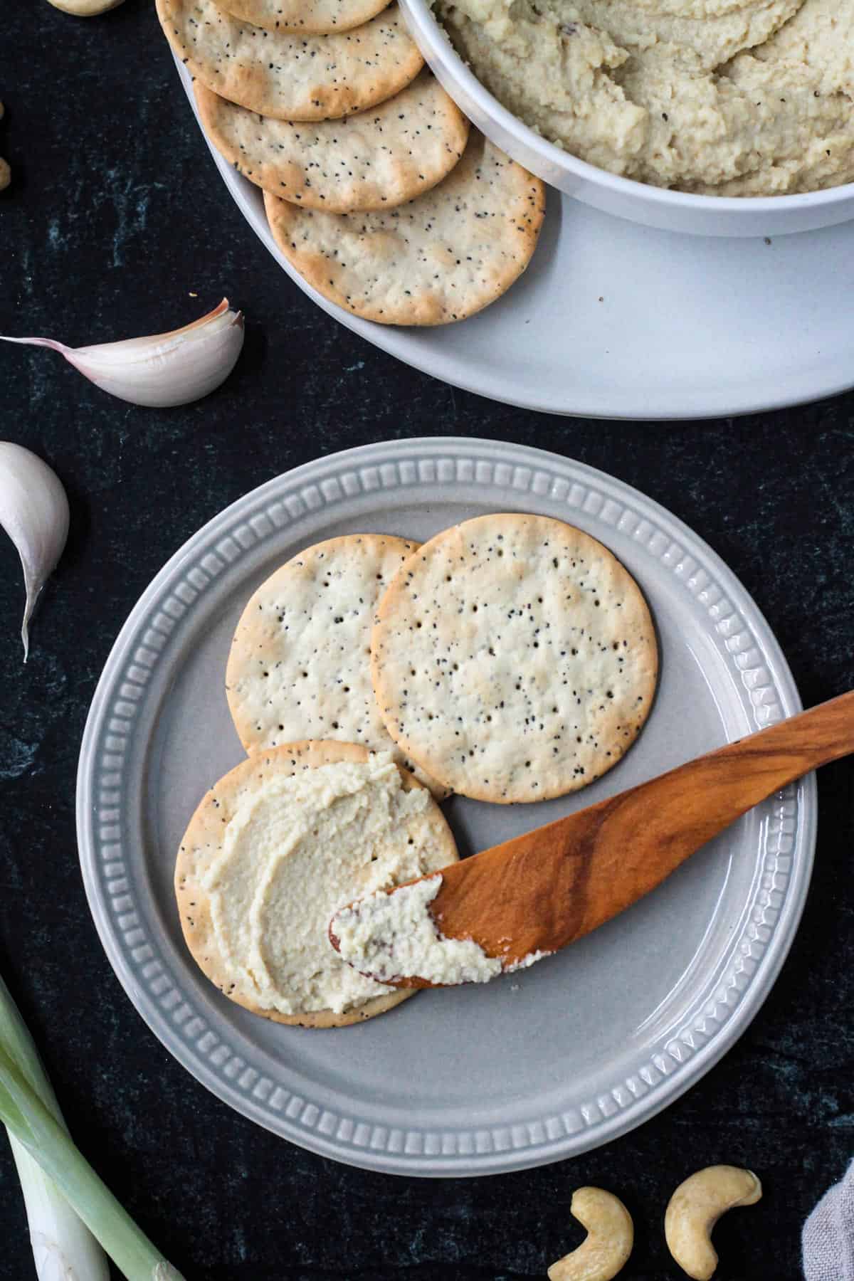 Ricotta spread on one cracker next to two plain crackers.
