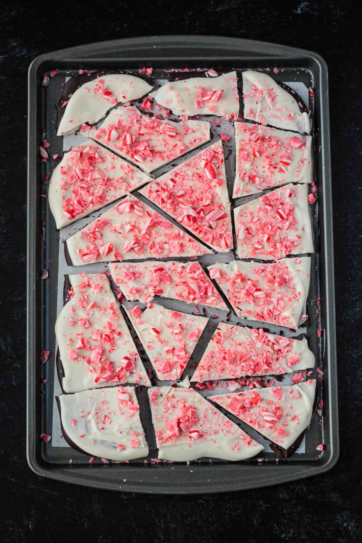 Slab of vegan peppermint bark broken into pieces.