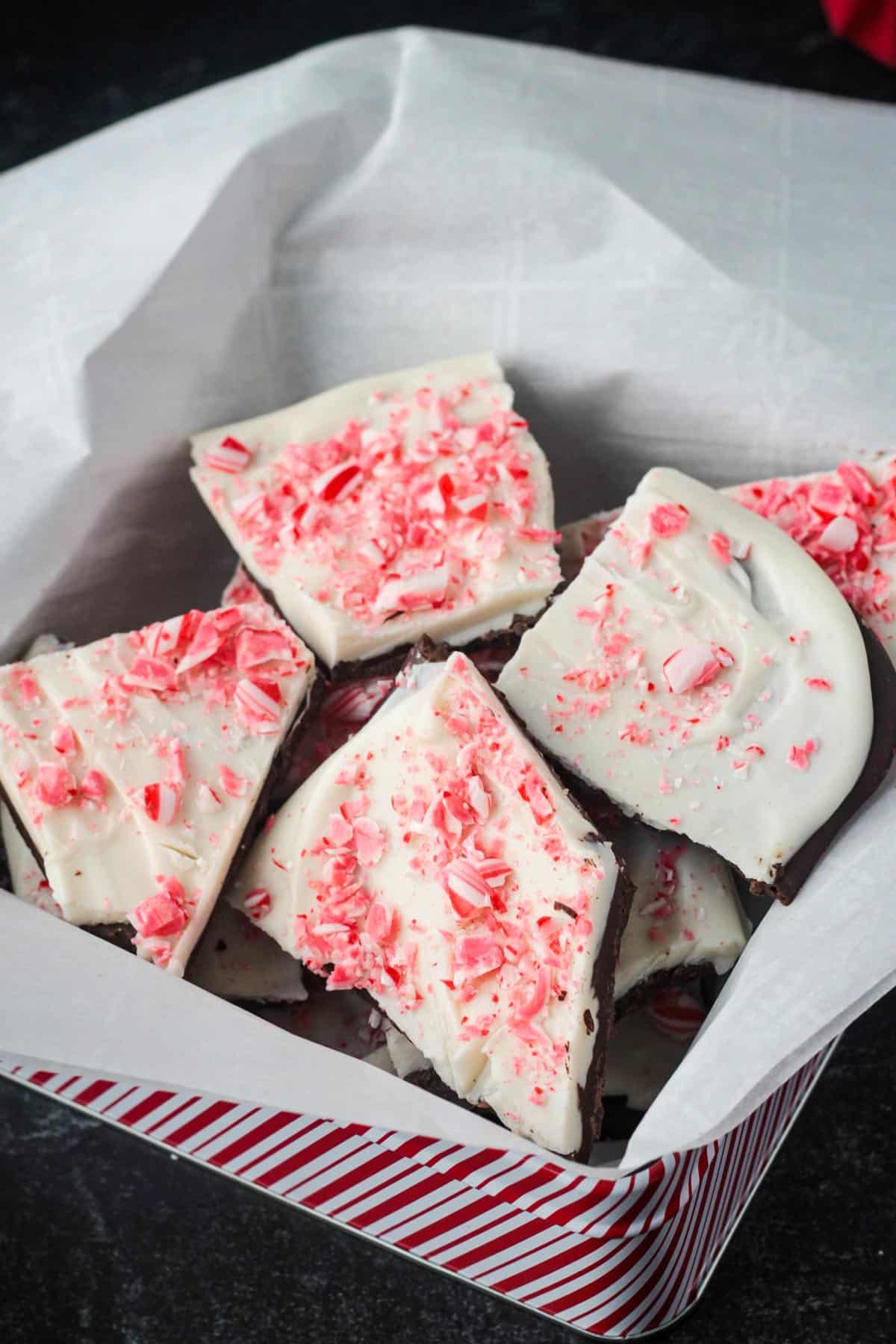 Gift box lined with parchment paper and filled with peppermint bark.