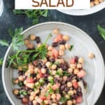 Plate of balela salad next to a serving bowl of more salad.