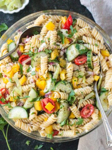 Pepperoncini Pasta Salad in a large bowl with fresh parsley scattered around the bowl.