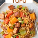 Kung pao tofu with noodles on a plate.