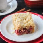 Slice of vegan orange cranberry cake on a plate.
